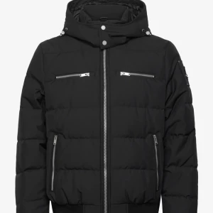 Moose knuckles jacka  - Snygg svart moose knuckles jacka med flera dragkedjor och hög krage. Jackan har en stilren design med ribbade muddar och är perfekt för kyligare dagar. Den har en modern look och passar bra till olika outfits. Köpt för 11000kr på Boozt mitt pris är 5500kr kvitto finns kvar och jackan ligger kvar i original förpackningen , kan bara mötas upp