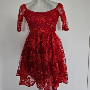 Röd handmade klänning från Malicious Designs  - Röd handsydd spetsklänning ''The Amanda Dress'' från Malicious Designs. Mycket fint skick, endast använd fåtal gånger. Onesize men uppskattar att den passar XS-S bäst. Jag köpte den för ca 1970 kr med frakt och importmoms inräknat.  Rökfritt hem men har katter.