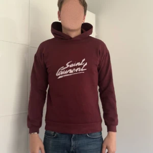 Vinröd hoodie från Saint Laurent - Säljer en snygg vinröd hoodie från Saint Laurent. Tröjan är frabriks fel från Saint Laurent. Skick 10/10 förutom fabriksfelen. Men man ser inte det direkt. Storleken är S men passar M. Pris 2100. Kom med frågor. Fler bilder kan ni även få de e ba å fråga. Kom även med bud 