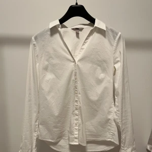Vit skjorta från H&M - Säljer en klassisk vit skjorta från H&M i storlek 38. Skjortan är figursydd och v- ringad, perfekt för en stilren look. Bara att skriva om fler bilder önskas💕