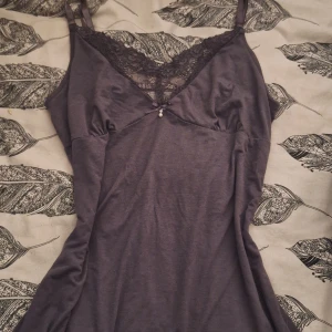 Lila spets topp - Jättefin lila klänning/topp med spetsdetaljer vid halsringningen och en liten rosett med pärla framtill från märket "Lingadore"💕🙏🏼 Justerbara band & i väldigt bra skick då den aldrig kommit till användning.