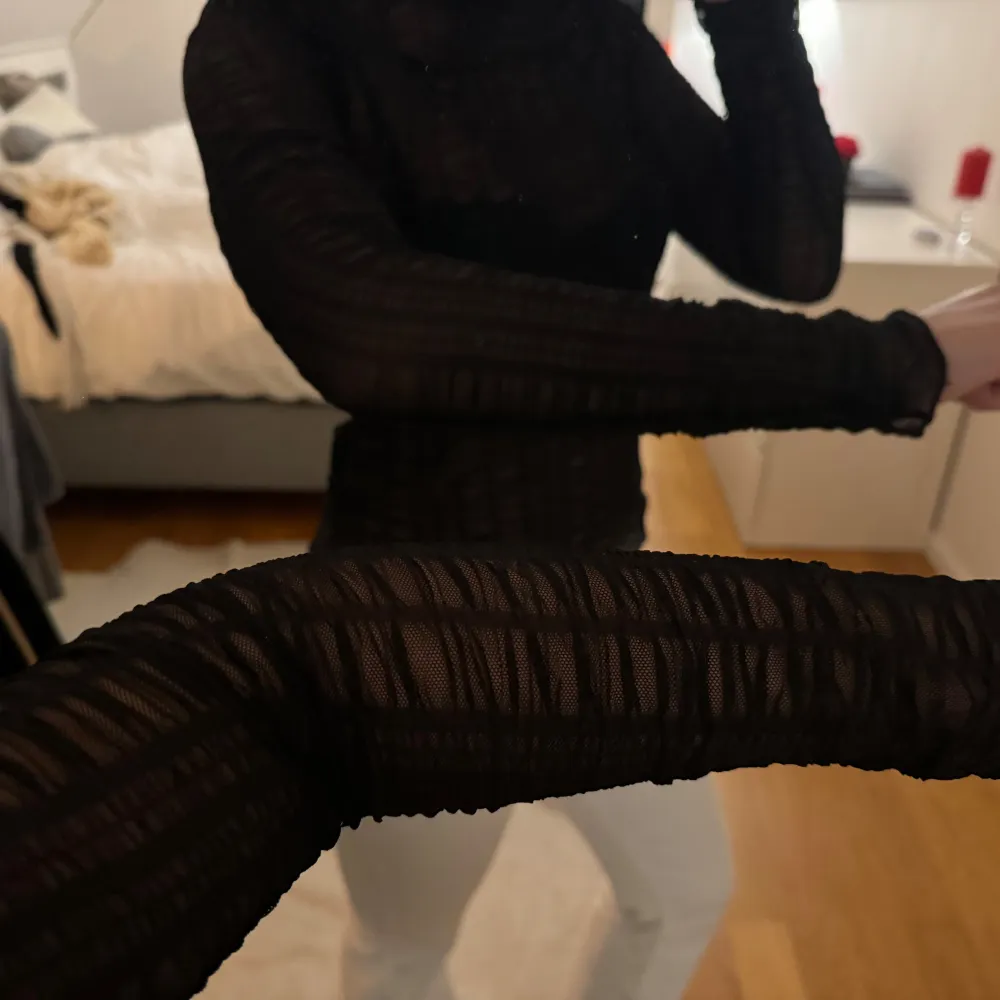 Snygg svart transparent topp med lång ärm och hög hals. Står ej strl men skulle uppskatta till xs/ s. Yläosat.