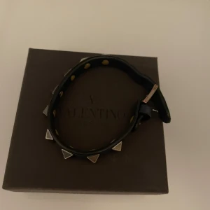 Mörk blått Valentino Garavani armband - Snyggt mörkblått armband från Valentino med silverfärgade pyramidformade nitar. Kommer med originalförpackning och tygpåse samt kvitto. Skick 6-7/10 nytt pris 2800 kr mitt pris 1100 kr