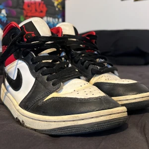 Nike Air Jordans i svart, vitt och rött - Säljer ett par klassiska Nike Air Jordans i svart, vitt och rött. Skorna har en cool design med snörning och är i bra skick. Perfekta för både vardag o chilla i stan. Pris kan diskuteras vid snabb affär 