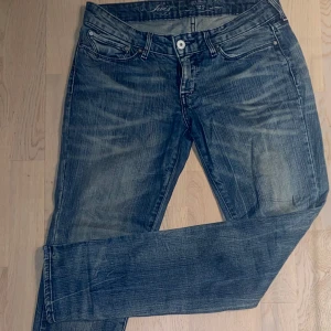 Blå jeans från Levi's - Säljer ett par klassiska blå jeans från Levi's med en snygg tvätt och femficksdesign. De har en knappgylf och är perfekta för en avslappnad stil.