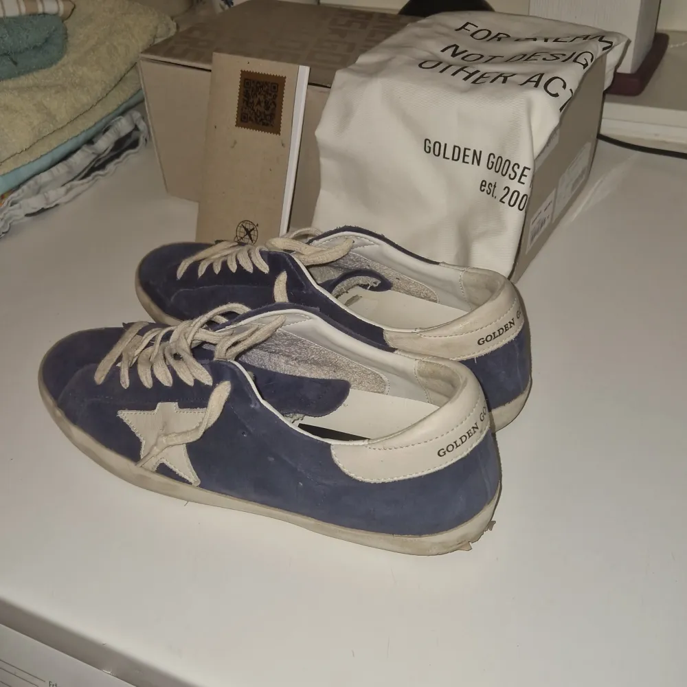 Säljer ett par snygga blå sneakers från Golden Goose i bra skick. Skorna är i mocka och har en vintage-look med en vit sula. Perfekta för en avslappnad stil! Priset börjar på 3000 men är öppen för bud!. Skor.