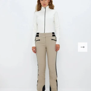 8848 altitude Beige skidbyxor med svarta detaljer  - Snygga beige byxor med svarta detaljer och dragkedjor fram. De har en tight passform. Byxorna har en hög midja och är gjorda i ett slitstarkt material. Från 8848 altitude, nypris 2500kr. 