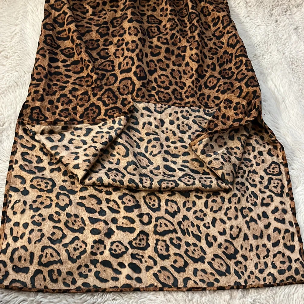 Säljer en supercool leopardmönstrad kjol i brunt och svart. Kjolen är i ett mjukt och glansigt material, perfekt för att sticka ut på festen eller bara för en vardagslook med attityd. Den har en elastisk midja för extra komfort. Passar perfekt till både sneakers och klackar! Men slits på båda sidorna.. Hameet.