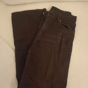 Bruna vida jeans från Monki - Snygga bruna vida jeans från Monki med klassisk design. Perfekta för en stilren look. Snygga i brun färg! 