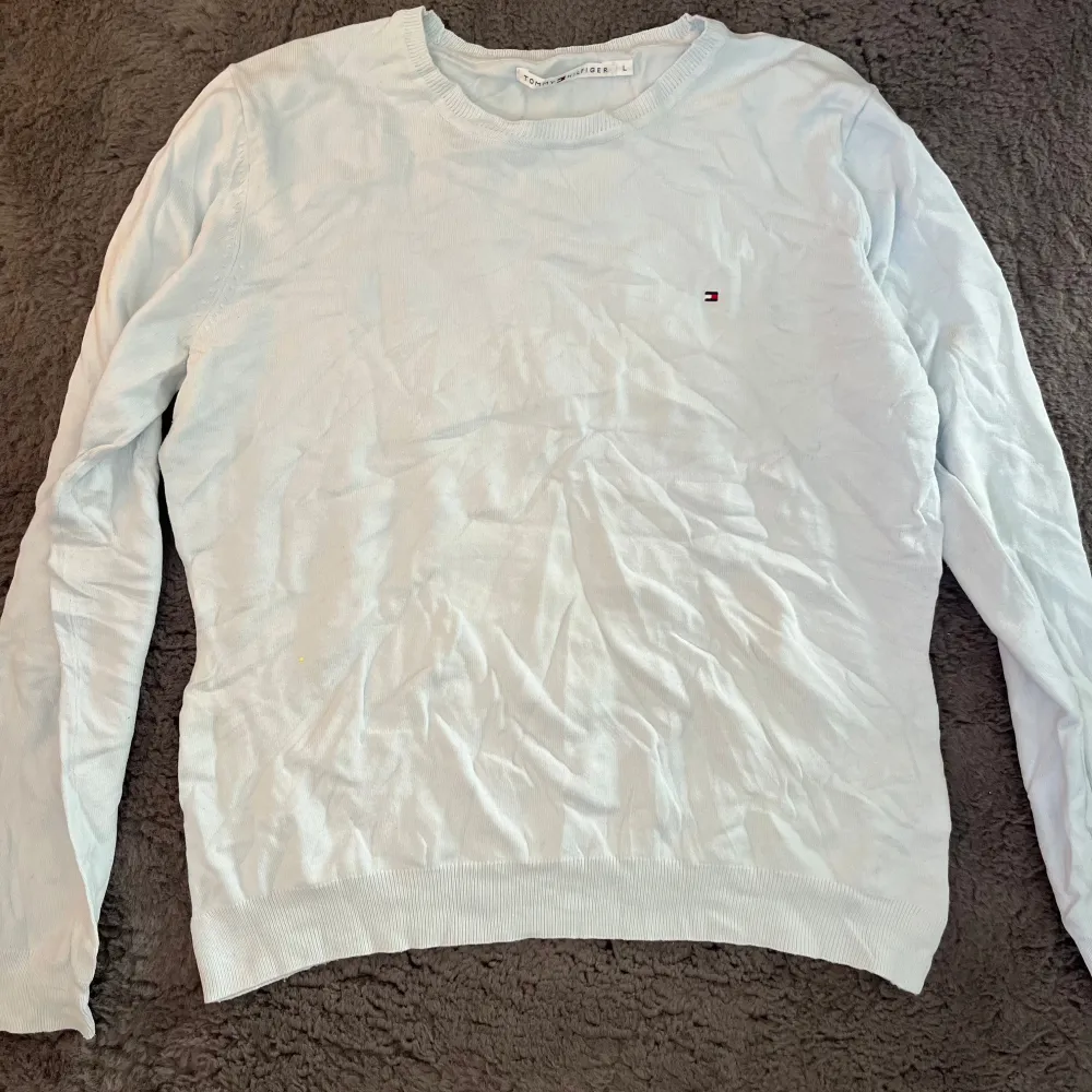 Säljer en stilren ljusblå tröja från Tommy Hilfiger. Den är i bra skick och har en liten logga på bröstet. Passar även M. Neuletakit & Villapaidat.
