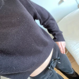 Stickad tröja - En svart stickad tröja som inte kommer till användning längre.