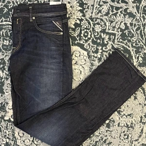 Mörkblå jeans från Replay - Säljer ett par snygga mörkblå jeans från Replay, modell Grover, storlek 31/32. De har en straight passform och är i nytt skick (aldrig använda). Perfekta för både vardag och fest! 🕺