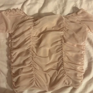 Beige topp från Amisu - Säljer en stilren babyrosa topp från Amisu med korta ärmar och rynkade detaljer framtill.