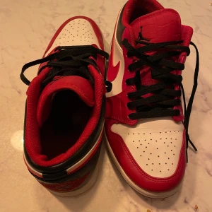 Nike Air Jordans i rött och vitt - Snygga Nike Air Jordans i rött och vitt med svarta snören. Perfekta för dig som vill ha en klassisk och stilren sneaker med ikonisk design.
