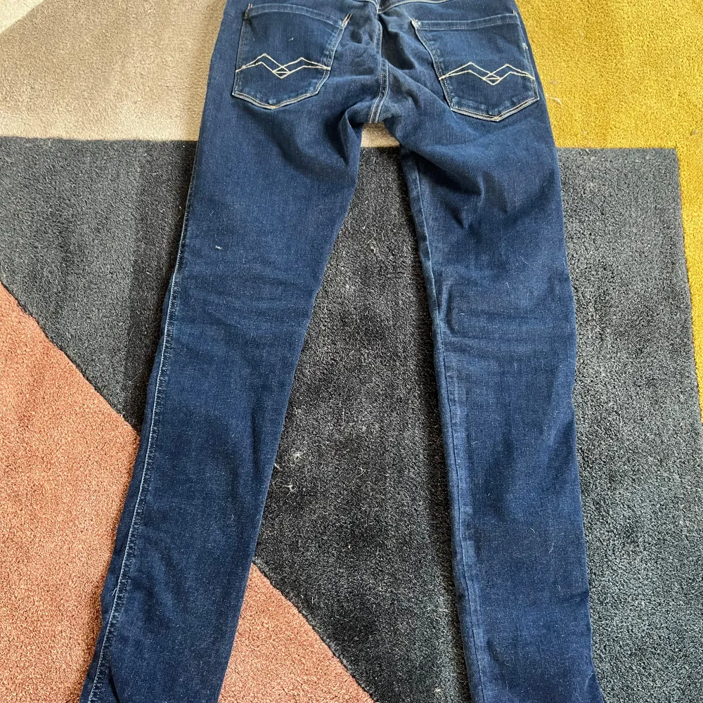 Säljer ett par snygga mörkblå Replay jeans i slim fit. De har en klassisk femficksdesign med coola sömmar på bakfickorna. Perfekta för både vardag och fest! Ny pris går runt 1000-2200kr. Jeans & Byxor.