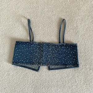 ZARA jeanstopp med strass  - Otroligt snygg topp från ZARA med strass. Cool att styla över skjorta eller bara som den är. Använd endast en gång. Hakarna har lossnat i ryggen en på varje sida, går att laga för den händige. 