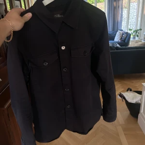 Oscar jacobson Overshirt  - Tja säljer min Oscar jacobson Overshirt som är i färgen navyblue. Nypris ligger på 3999kr men lägger släpper den billigt vid en snabb affär! Den är i storlek 48 vilket motsvarar ish M, jag har M i de flesta plaggen och den sitter bra🙌🏼