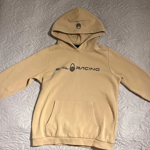 Beige hoodie Sail Racing - Vill du ha en skön och bekväm hoodie då ska du kolla in denna! En använd hoodie men är i relativt bra skick förutom lite nopprig i luvan. Köpt för 700kr