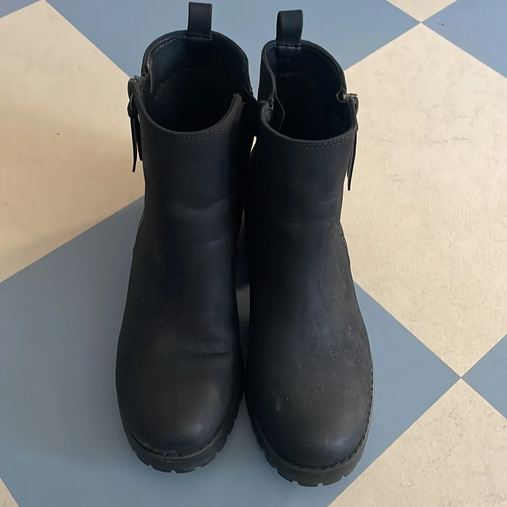 Säljer ett par svarta boots med dragkedja på sidan. De har en robust sula och en liten klack, perfekt för höst och vinter. Bootsens stilrena design gör dem lätta att matcha med olika outfits. Sköna, inte stiva.. Skor.