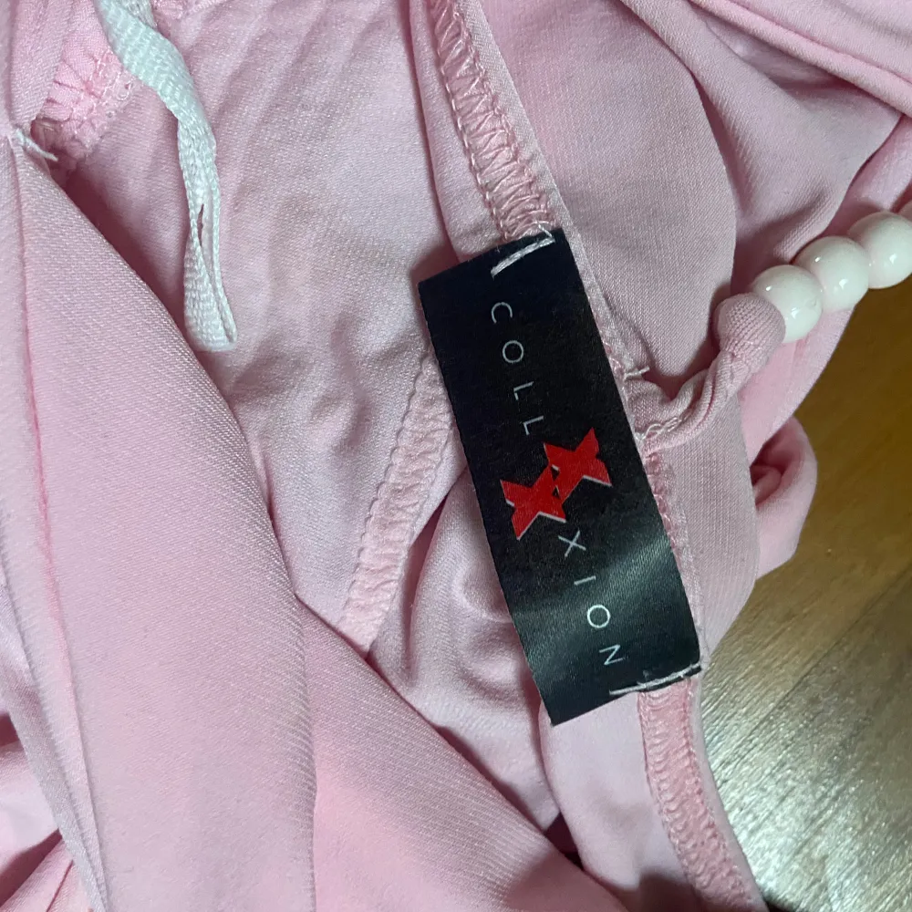 Säljer en söt rosa halterneck topp från X Collection. Toppen har en djup v-ringning och ett brett band under bysten med fina detaljer. Perfekt för sommarens fester eller en dag på stan!. Toppar.