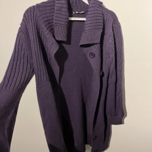 Lila kofta - En stickad varm kofta som är lika, oanvänd. 