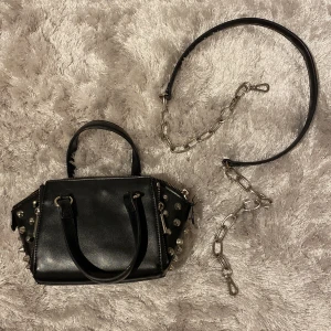 Cool zara väska  - Jätte snygg väska från zara. Helt slutsåld, finns inte att köpa längre. Bara andvänd fåtal gånger men är i toppenskick!! Väskan har tre fack och en liten ficka i den mellersta, så rymlig. Pris går absolut att diskutera!! (Axelkedja medföljer, finns lite defekter på kedjan)