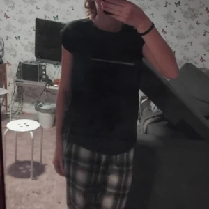 Svart t-shirt - En enkel svart t-shirt i ett mjukt material. Den har en normal passform och är ärmlös, vilket gör den perfekt för varma dagar eller som ett basplagg i garderoben.