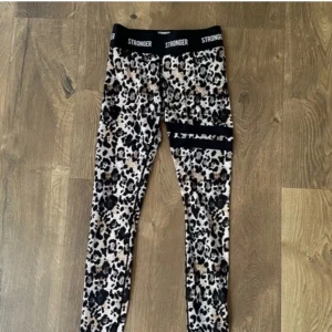 Leopardmönstrade leggings från Stronger - Snygga leopardmönstrade leggings från Stronger i mycket bra skick. De har en hög midja och är perfekta för träning. Materialet är stretchigt och bekvämt. Perfekta för dig som vill sticka ut på gymmet! Har inga egna bilder på! Så ni får skriva privat om ni vill ha egna bilder💕 nypris- 899kr pris kan absolut diskuteras💕