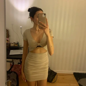 Beige kortklänning  - Snygg beige kortklänning från Shein i storlek S. Den har en cool knytning framtill och en liten cut-out detalj vid midjan. Perfekt för fester, finmiddag och nästa sommar! Materialet känns mjukt och stretchigt, vilket ger en bekväm passform. Jag köpte klänningen secondhand men har aldrig själv använt den, tycker den är jättebekväm och fin men har bara inte kommit till användning. 💕