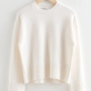 Vit stickad tröja från & Other Stories - Superfin vit stickad tröja från & Other Stories. Den är perfekt för kyliga dagar med sin mjuka och varma känsla. Tröjan har långa ärmar och en klassisk rund halsringning. Ribbstickade detaljer vid ärmslut och nederkant ger en snygg !