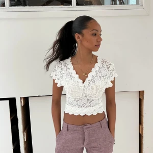 Vit spetsblus från Design by Si - Superfin vit spetsblus från Design by Si. Den är kortärmad med v-ringad design och spetsdetaljer. Har bara använt toppen en gång efter jag köpte den så den är som ny🥰