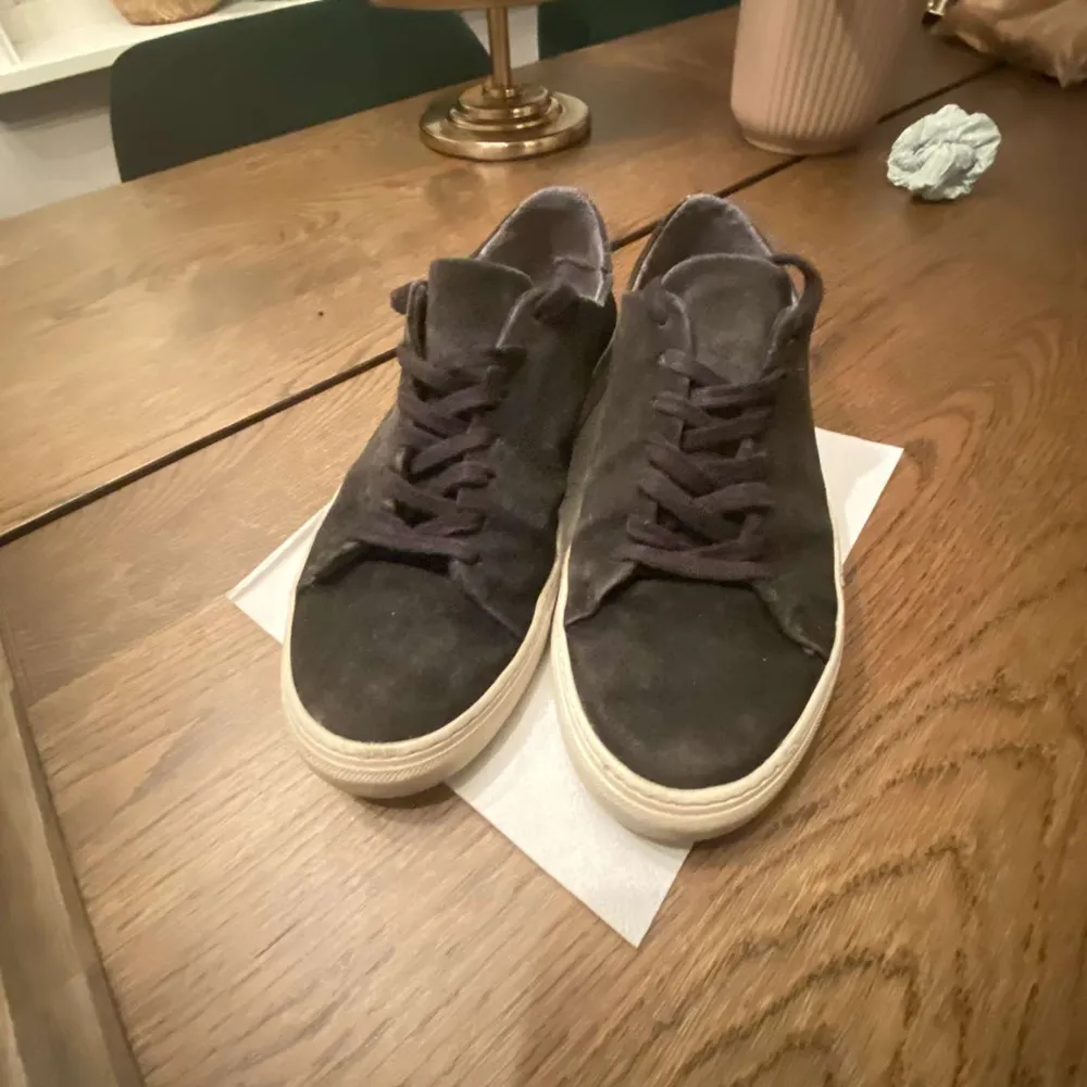 Säljer ett par svarta sneakers i mocka med vit sula. De har en klassisk design med snörning och är i bra skick. Perfekta för vardagsbruk och passar till de flesta outfits. Sulan har lite slitage men överlag är de i fint skick. Nypris ligger runt 1.5 tusen men säljer billigt pga skick.. Skor.