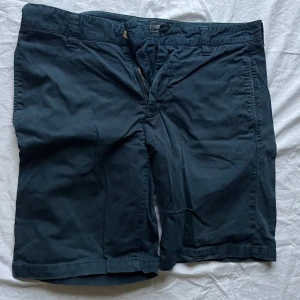 Mörkblå shorts från Boomerang - Säljer ett par mörkblå shorts från Boomerang i bra skick. De har en dragkedja fram och två bakfickor med knappar. Perfekta för sommaren och vårens varmare dagar. Passar till både vardag och lite mer uppklädda tillfällen. Storleken i byxorna står inte men jag har jämfört med ett annat par som har 34. 