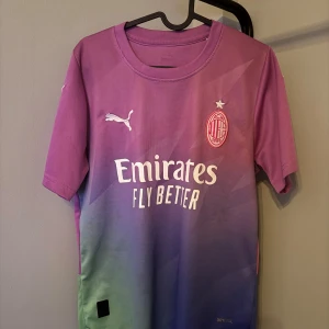 Lila och grön AC Milan fotbollströja - Säljer en snygg AC Milan fotbollströja i lila och grön från Puma. Tröjan har korta ärmar och är i mycket bra skick. Den har ett coolt färgskiftande mönster och klubbens emblem på bröstet. Perfekt för alla Milan-fans! 💜💚 självklart äkta nypris 1199 mitt pris 329 pris kan diskuteras
