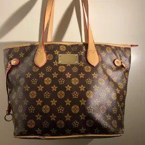 Säljer en snygg brun axelväska från Louis Vuitton med klassiskt monogrammönster i guld. Väskan har ljusbruna handtag och detaljer, samt en praktisk dragkedja på baksidan. Perfekt för både vardag och fest! 👜✨