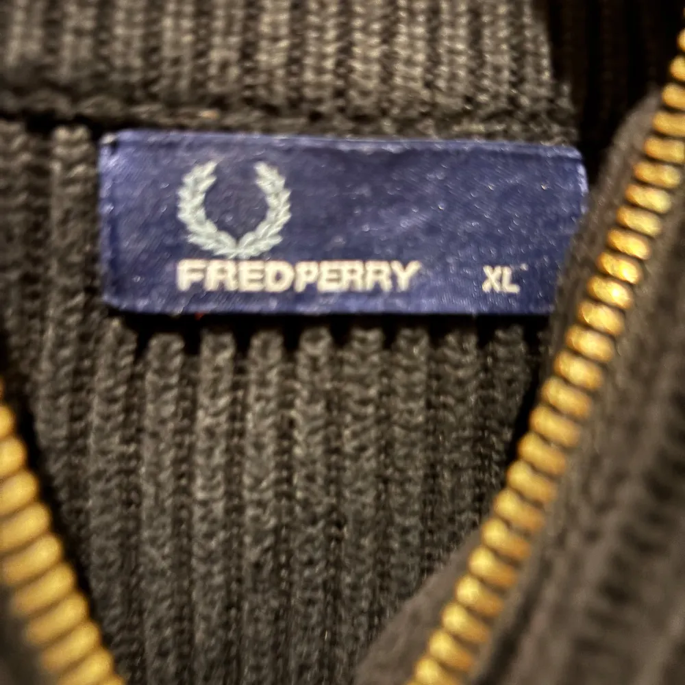 Säljer en snygg svart ribbad tröja från Fred Perry i storlek XL. Tröjan har en dragkedja framtill och är långärmad, perfekt för höst och vinter. Den är i mycket bra skick och passar både till vardags och fest. Perfekt för dig som gillar stilren design!. Tröjor & Koftor.