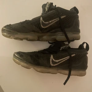 Svarta Nike Vapormax sneakers - Säljer ett par svarta Nike Vapormax sneakers. De har en cool design med synlig luftsula och stickat material. Skorna har snörning och är i behov av lite kärlek men funkar fortfarande bra för träning eller vardagsbruk. Butikspris:2300kr