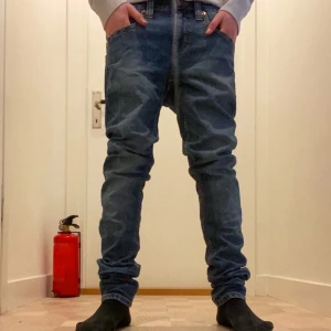 Blå jeans - Säljer ett par snygga blå jeans från 157 i modellen Rocket. Passform slim fit. De har en klassisk femficksdesign och är nyskick, skick 10/10. Perfekta för vardagsbruk med en bekväm passform. Säljer de för att de sitter lite tajt på mig. Endast testade. Storlek Xs detsamma som W26-28 L30. Modellen på bilder är 160cm lång och väger ca 45kg. 