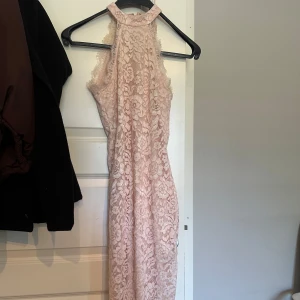 Ljusrosa spetsklänning - Säljer en superfin ljusrosa spetsklänning. Klänningen är ärmlös och har en hög halsringning, perfekt för sommarens fester eller en romantisk middag. Den är i mycket bra skick.