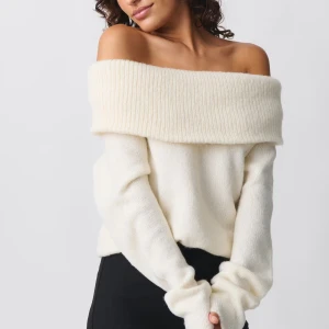 Vit offshoulder stickad tröja - Superfin vit offshoulder tröja som är perfekt för både höst och vinter. Den är stickad och har långa ärmar, vilket gör den både mysig och stilren. Använd en gång och är i nyskick! SLUTSÅLD
