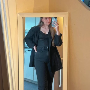 Linne i strukturerad läderimitation  - Använd fåtal gånger, som ny.  Normal i storleken, skönt stretchigt material med justerbara axelband🫶 Materialet upplevs något glittrig i flash-ljus men väldigt subtilt då den är mattsvart.