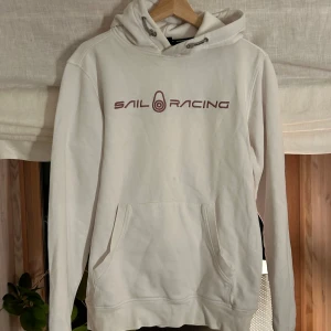 Sail Racing hoodie  - En superfin hoodie i märket Sail Racing. Den har en liten liten fläck på framsidan som säkert går bort med något bra medel! super fint skick annars och inga andra defekter. 