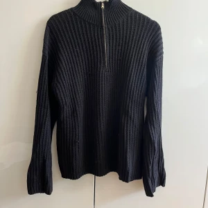 Stickad tröja med dragkedja  - Stickad tröja från nakd med halvzip. Har en liten skada framtill som går att se på bilderna men inget markant. Ganska lång i både passform och ärmar. I fint men använt skick