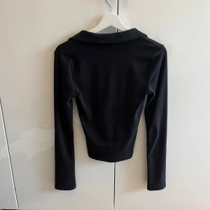 Svart topp  - Svart topp från Gina tricot. Djupare urringning och långa lite vidare ärmar. 