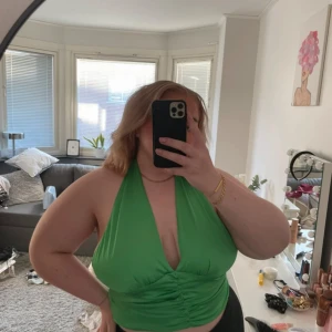 Grön croptop - Grön croptop med knyte i nacken och resår ruggen från Gina Tricot. Köpt på Vinted, aldrig använd av mig.