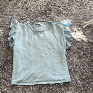 Blå zaratopp - Superfin blå topp med volang från zara. Endast använd fåtal gånger🩷