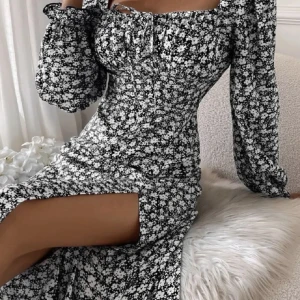 Klänning  - En blommig klänning i storlek S med urringning och långa ärmar. Slits i sidan och figurframhävande passform. Blixtlås på baksidan. Sökord/Keywords: blommig klänning, floral dress, urringning, neckline, långa ärmar, long sleeves, slits, slit, figurfra