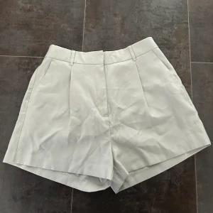 Kostymshorts - Kostymshorts i en grå-vit nyans. Fickor och pressveck. Nyskick, prislapp kvar. 💕