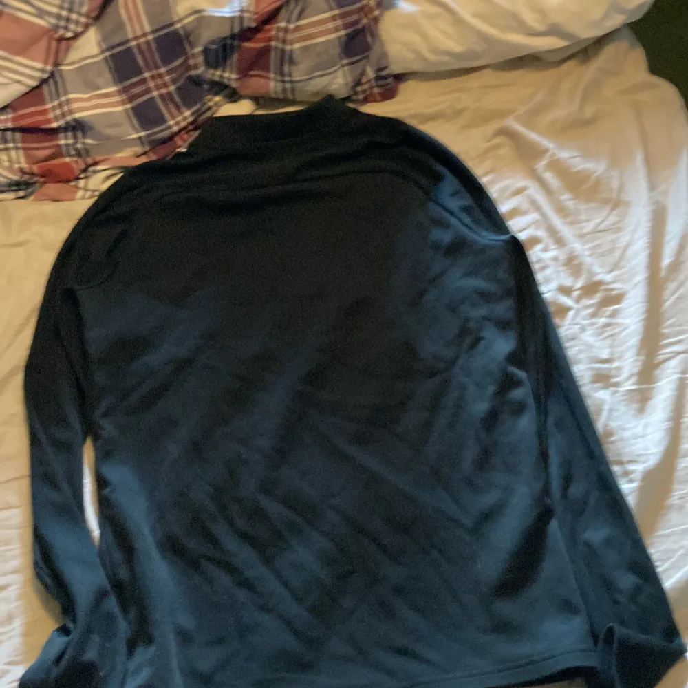 Säljer en svart långärmad tröja från Nike med Dri-FIT-teknologi. Perfekt för träning eller vardagsbruk. Tröjan har en dragkedja vid halsen och en vit Nike-logga på bröstet. Den är i bra skick och superbekväm att ha på sig. Passar perfekt för höst och vår!. Tröjor & Koftor.