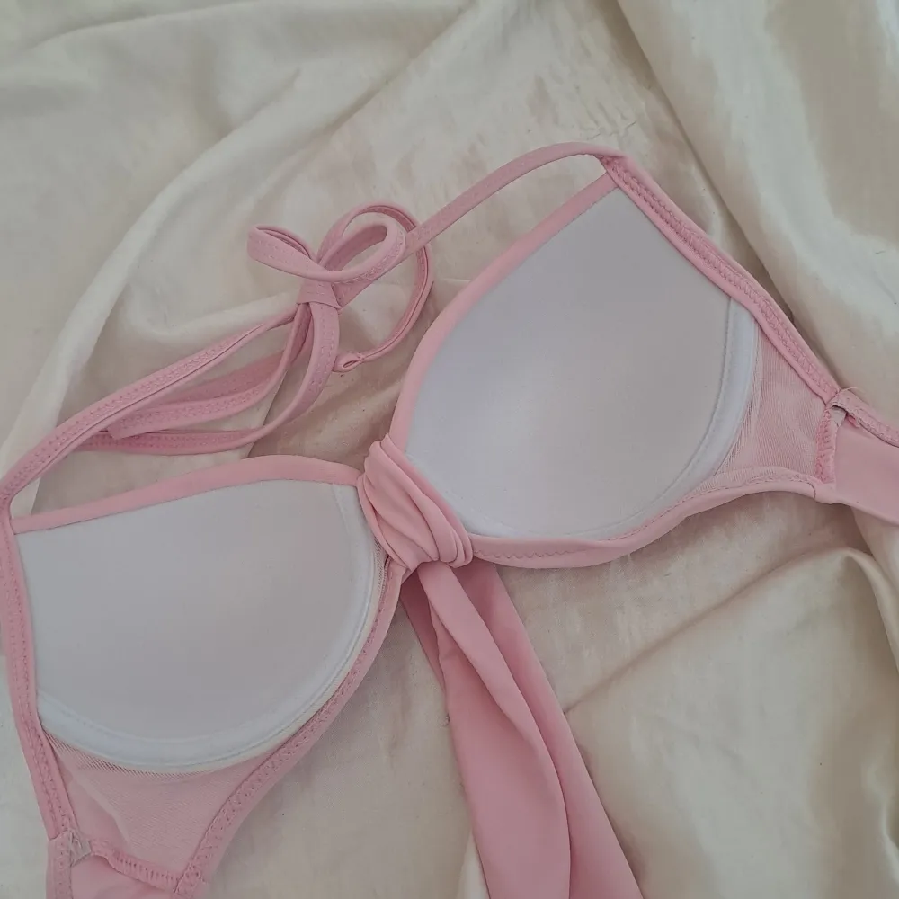 Säljer en superfin rosa bikiniöverdel i storlek XS. Den har en söt knytning framtill och är gjord av 82% polyester och 18% spandex, vilket gör den både bekväm och stretchig. Perfekt för sommarens alla badäventyr! 💖. Övrigt.